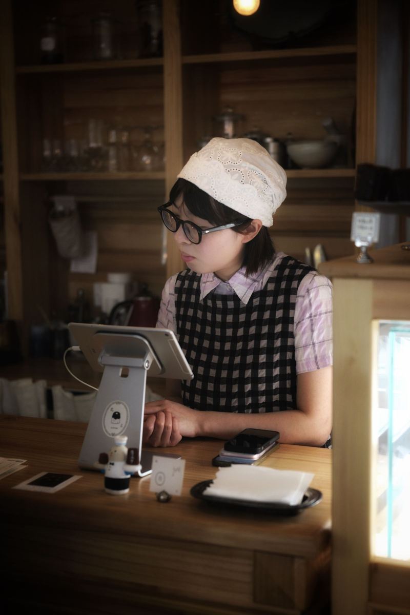 Barista taking an order on a tablet at a café counter