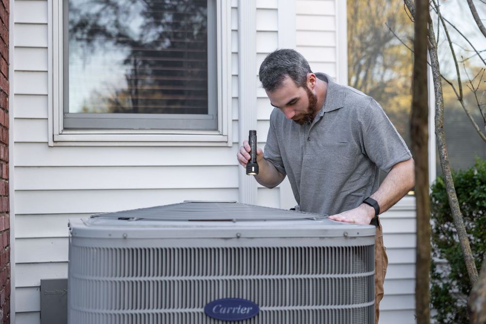 Technician servicing an outdoor air conditioning unit